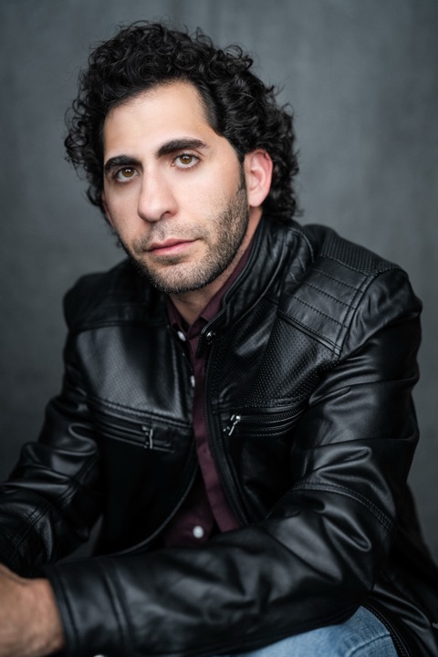 Luca Cundo in a leather jacket against a grey backdrop