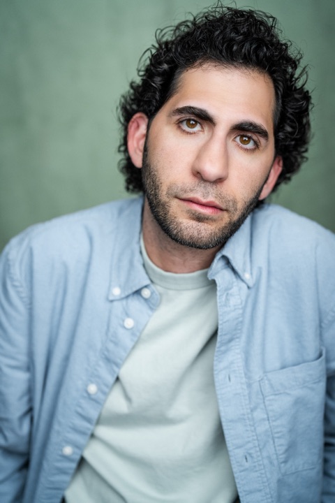 Luca Cundo in a light blue shirt against a green backdrop