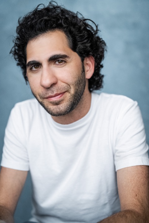 Luca Cundo in a white t-shirt against a blue backdrop