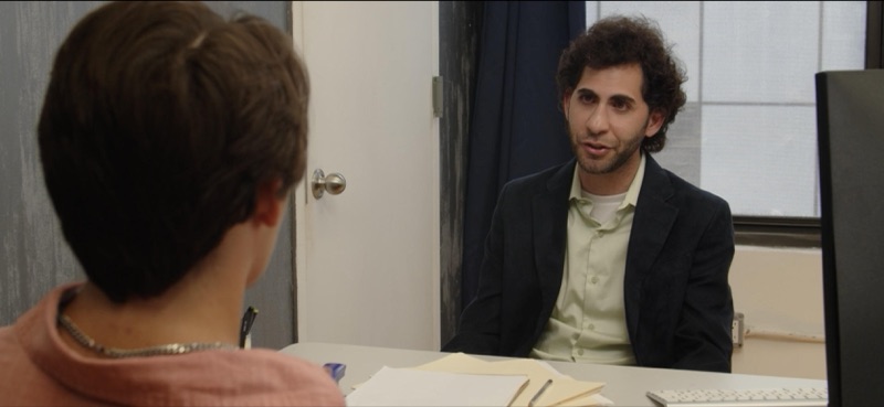 Luca Cundo across a desk from a student in The Principal